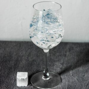 a glass of water with ice cubes on a table