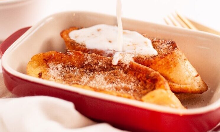person pouring milk on white ceramic bowl